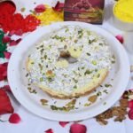 Close-up of Meetha Ghewar soaked in sugar syrup with almond and pistachio garnish