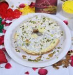 Close-up of Meetha Ghewar soaked in sugar syrup with almond and pistachio garnish