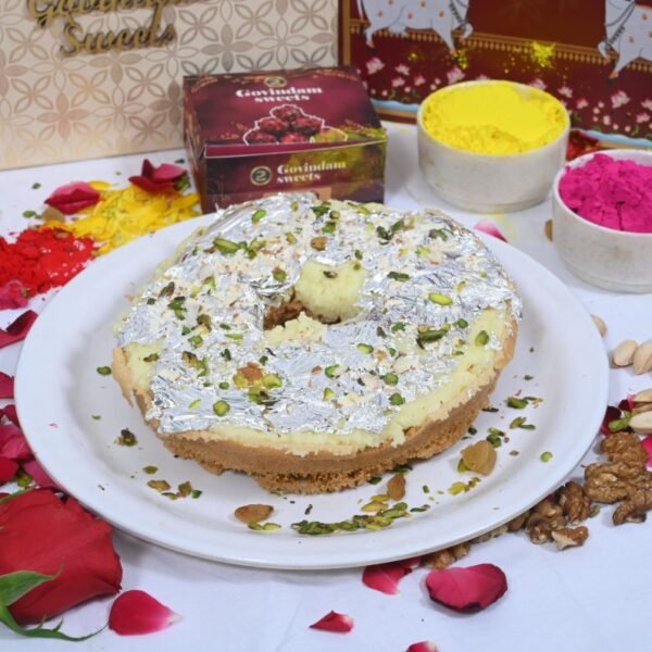 Meetha Ghewar served on silver thali with marigold flowers and festive elements