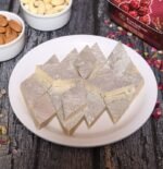 Kaju Katli served in a traditional Indian sweet thali