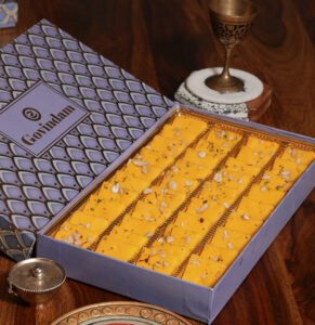 Mohan Thal served on brass plate with cardamom pods and cashews